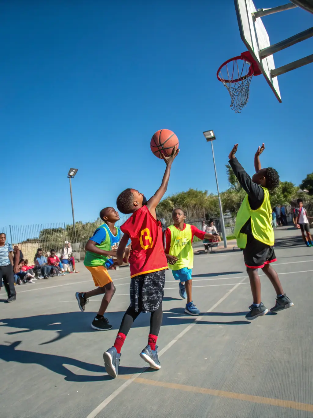 A diverse group of children participating in a basketball summer camp organized by Ligue Sud BB, showcasing inclusivity and community engagement.